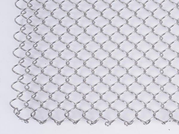 A piece of stainless steel metal coil drapery mesh curtain on white background.